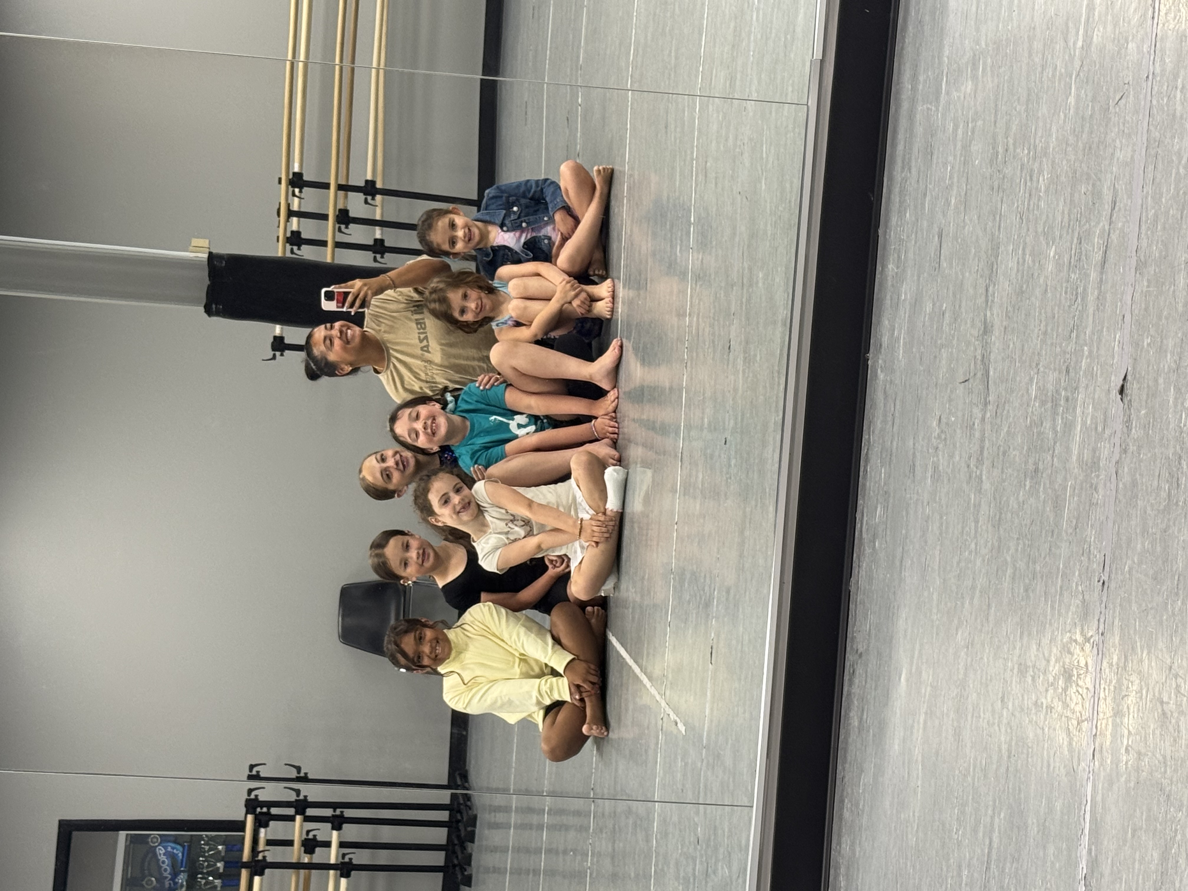 Michaela with kids on the studio floor from earlier teaching, not a current adult Move Fit class